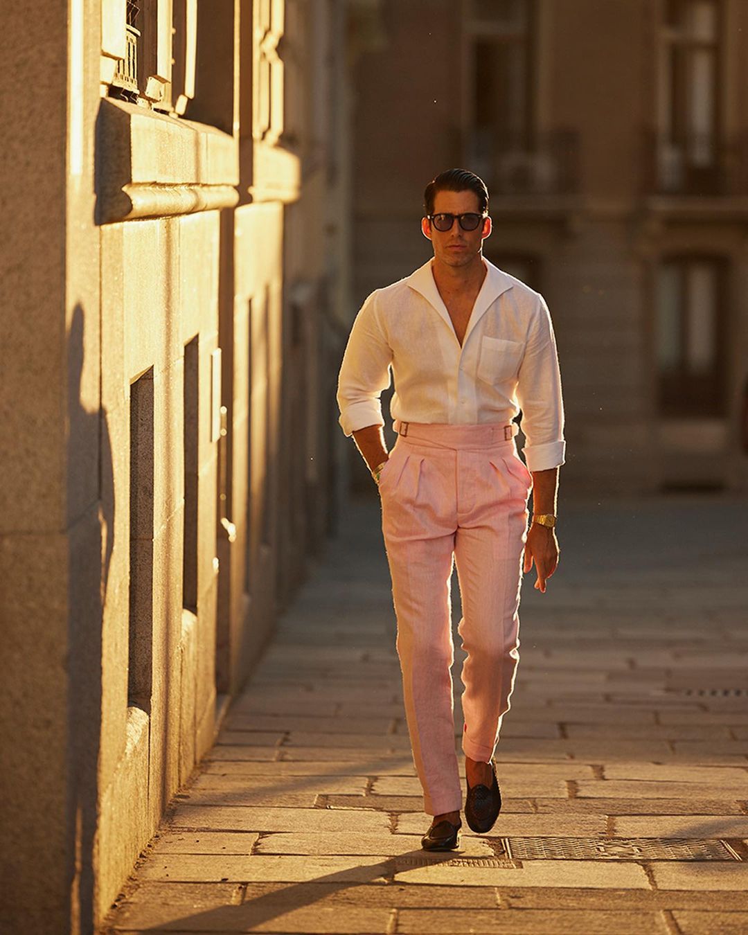Male model outside wearing custom linen Gurkha pants for men by Luxire in pink twill