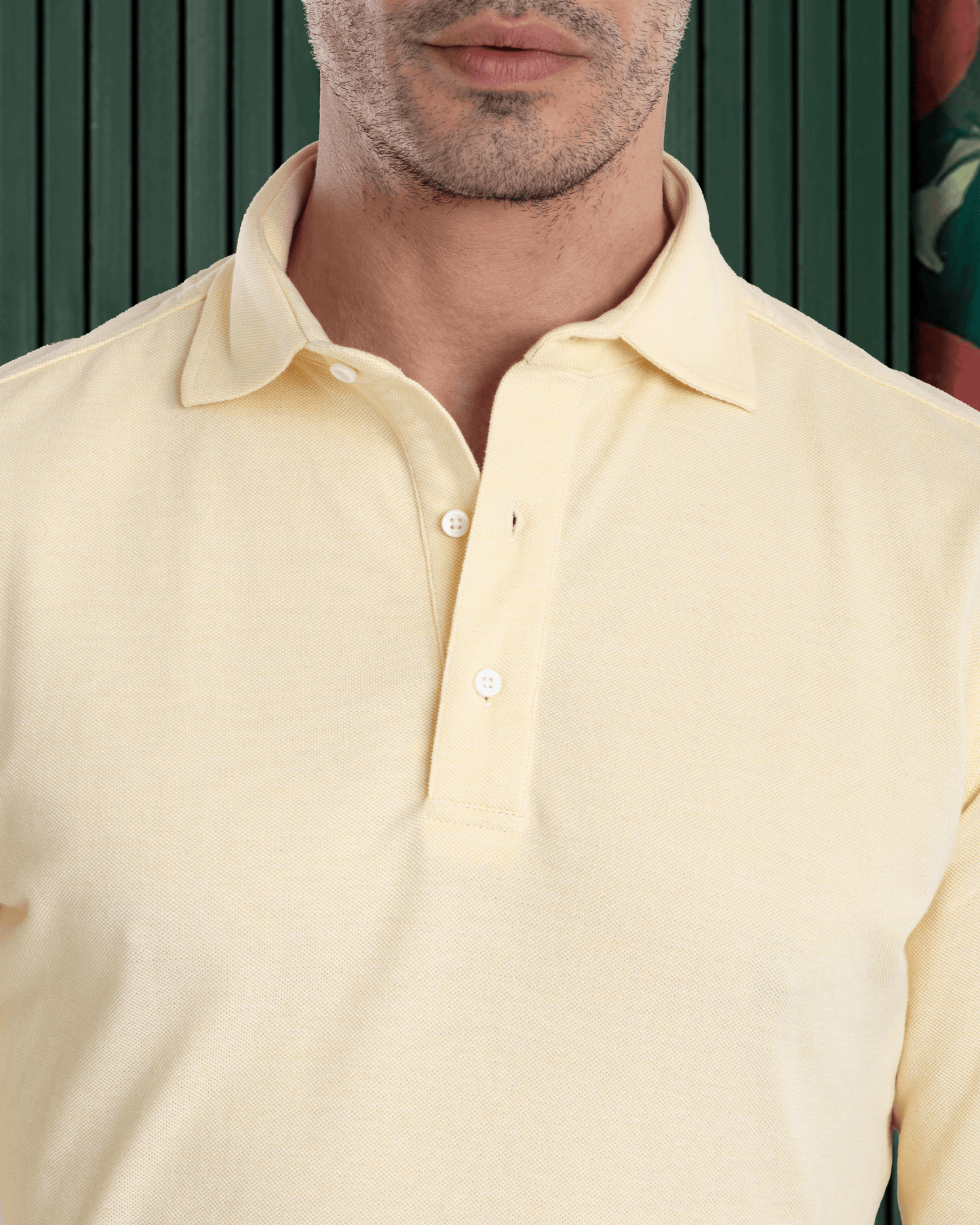 Close up of model wearing the custom oxford polo shirt for men by Luxire in butter yellow