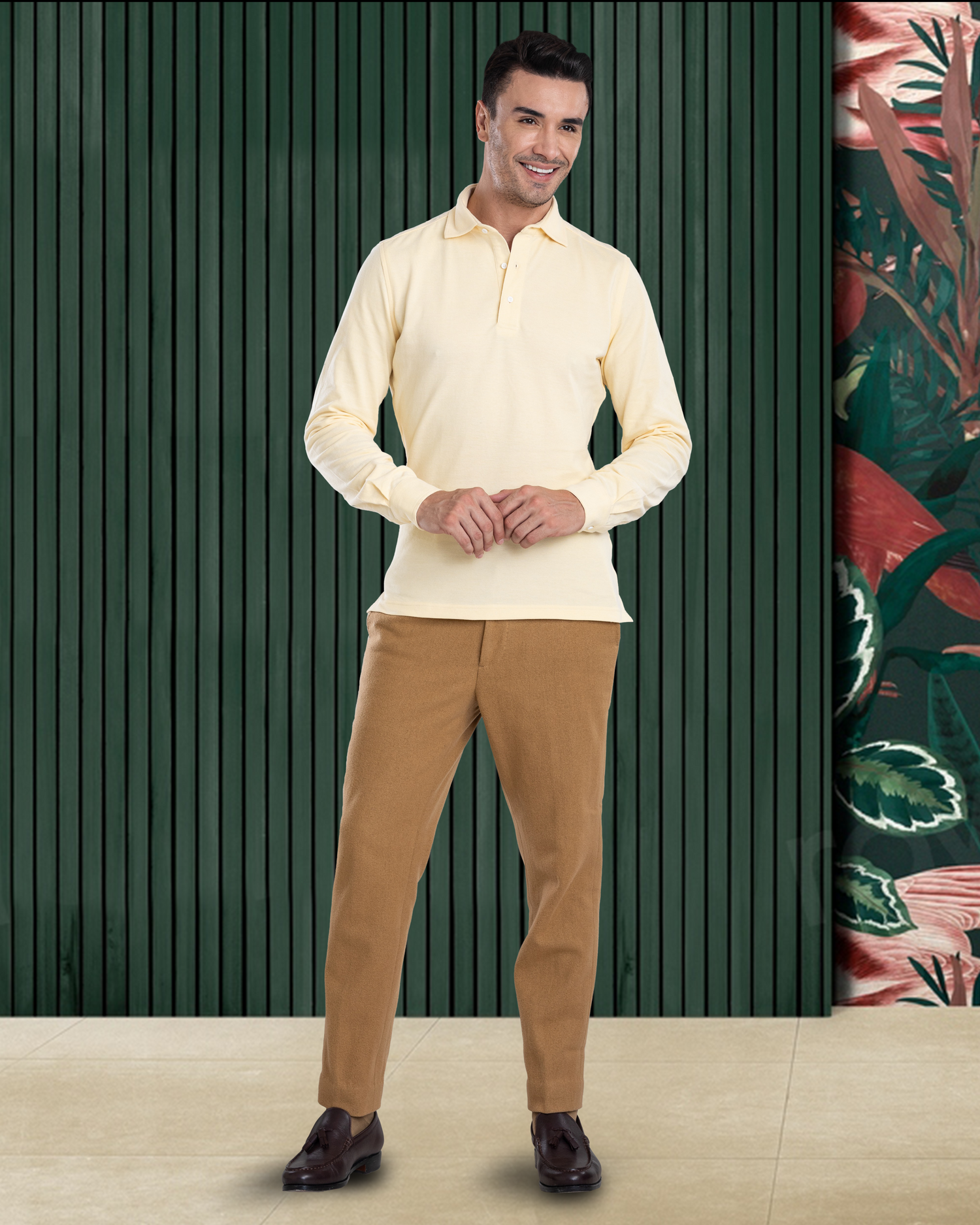 Model wearing the custom oxford polo shirt for men by Luxire in butter yellow hands together