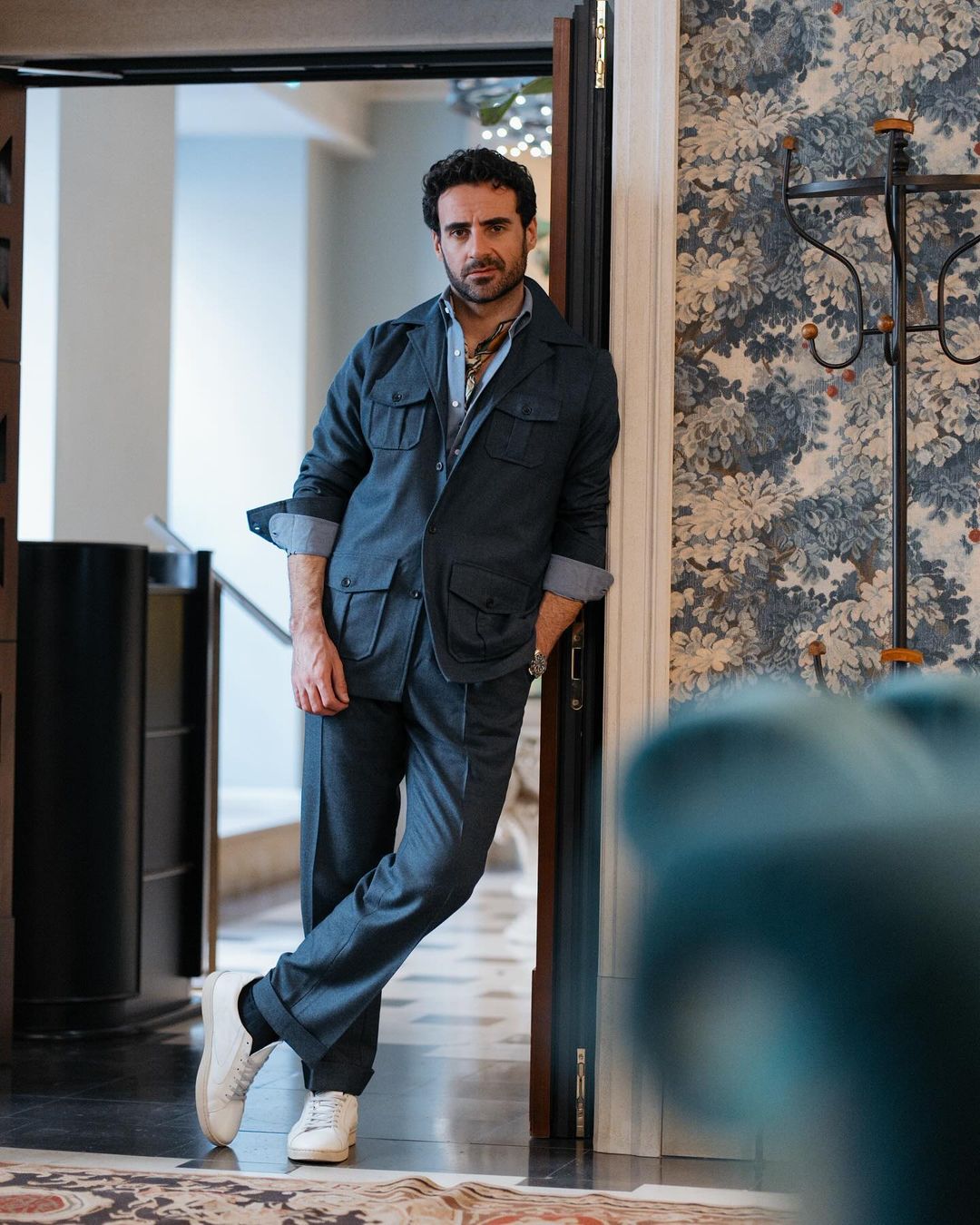Model leaning in door frame wearing the wool flannel shirt jacket for men by Luxire in navy blue