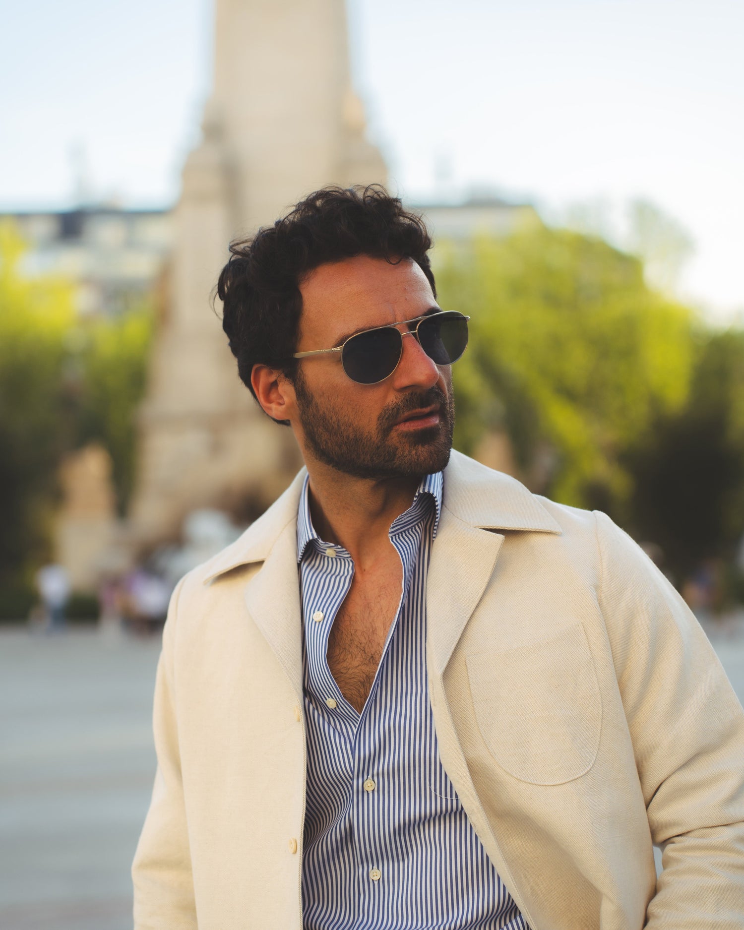 Model outside wearing the linen shirt jacket for men by Luxire in cream wearing sunglasses 12