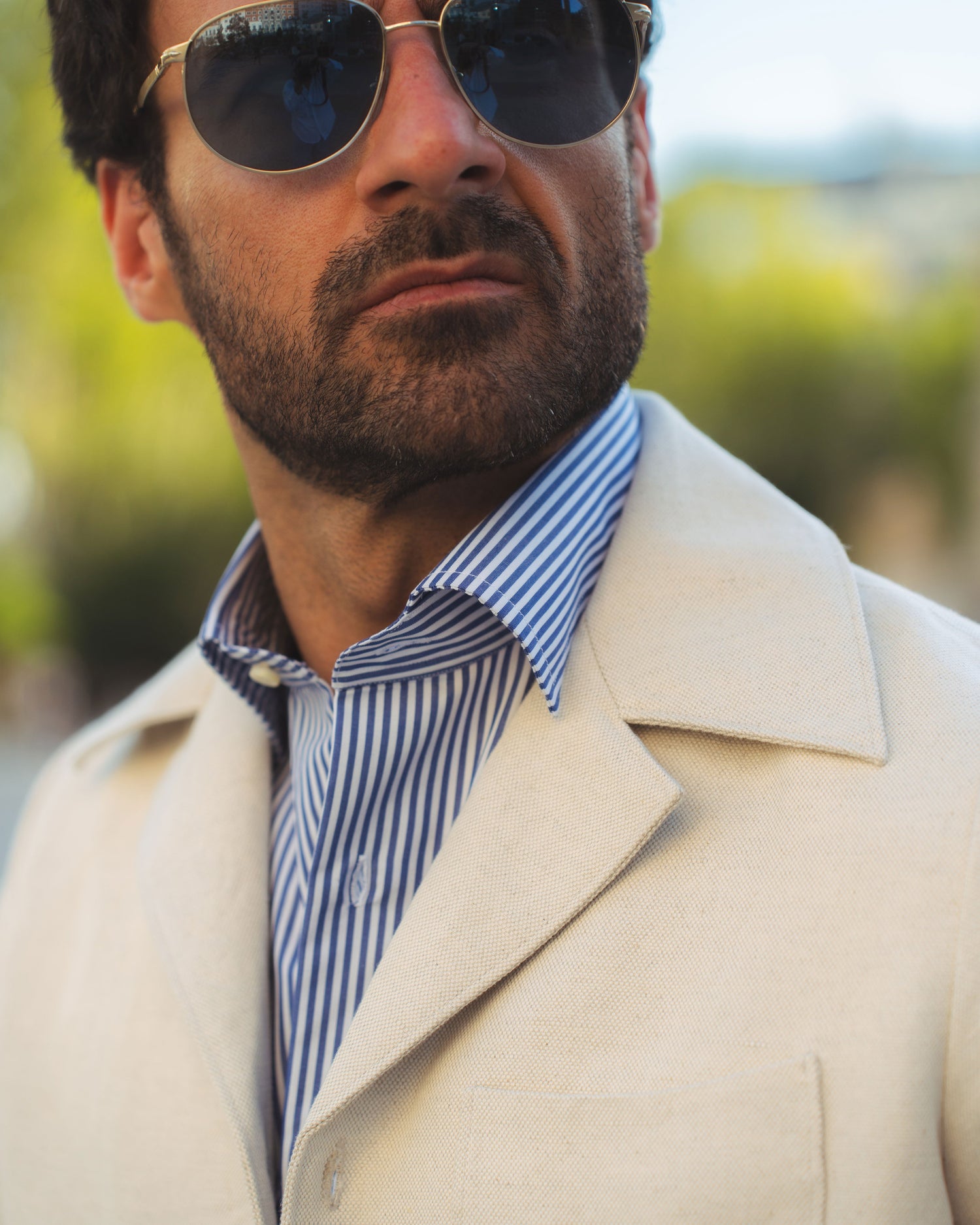 Model outside wearing the linen shirt jacket for men by Luxire in cream wearing striped shirt 6