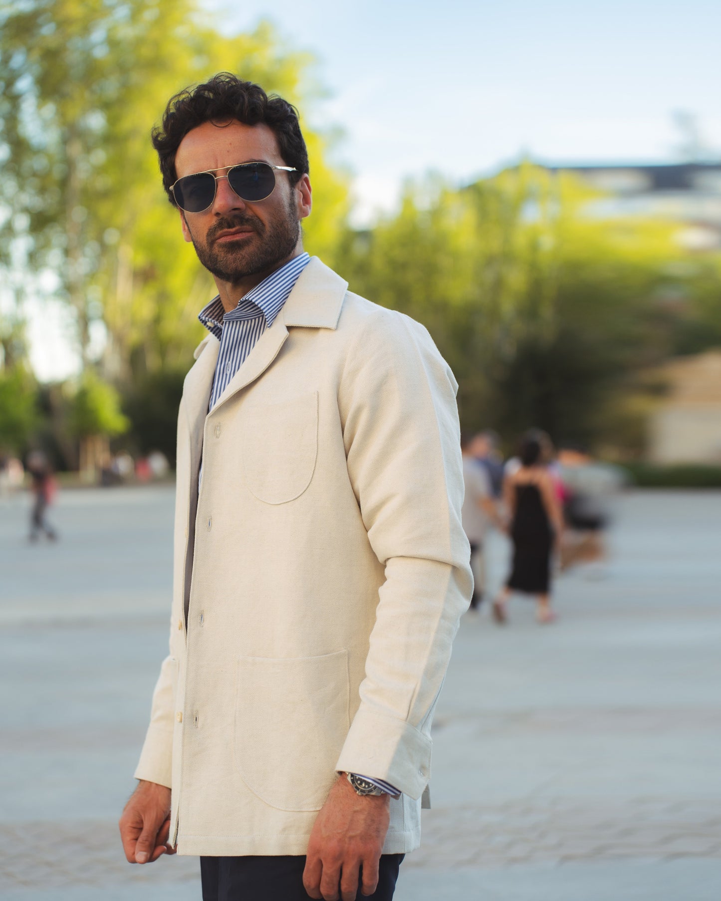 Model outside wearing the linen shirt jacket for men by Luxire in cream wearing striped shirt 4