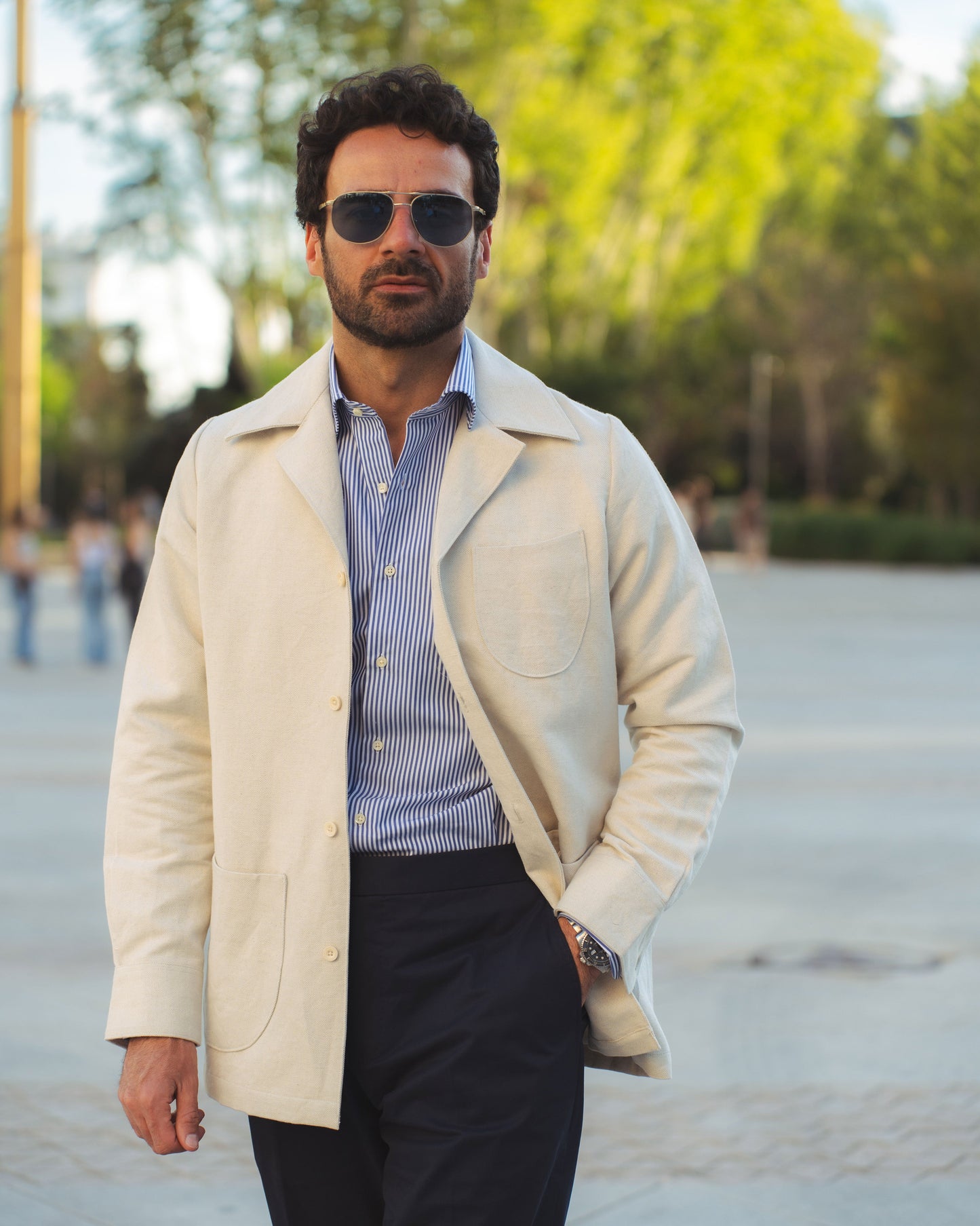 Model outside wearing the linen shirt jacket for men by Luxire in cream wearing striped shirt 5