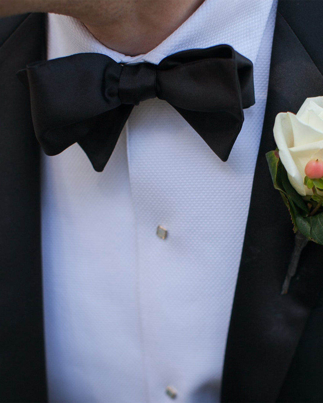 Close up of model wearing the mens tuxedo shirt by Luxire called classic with black bow tie