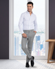 Model wearing custom wool Chino pants for men by Luxire in grey in front of window