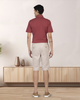 Model wearing custom Genoa shorts for men by Luxire in pale green wearing red top hands at side