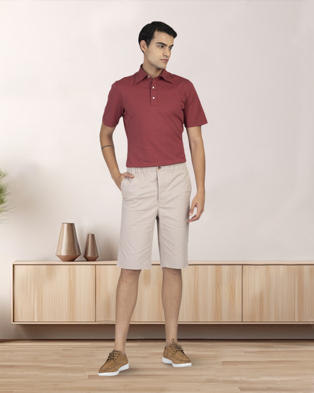 Front of model wearing the custom oxford polo shirt for men by Luxire in soft marsala one hand in pocket