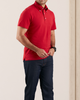 Model wearing the custom oxford polo shirt for men by Luxire in red hands together