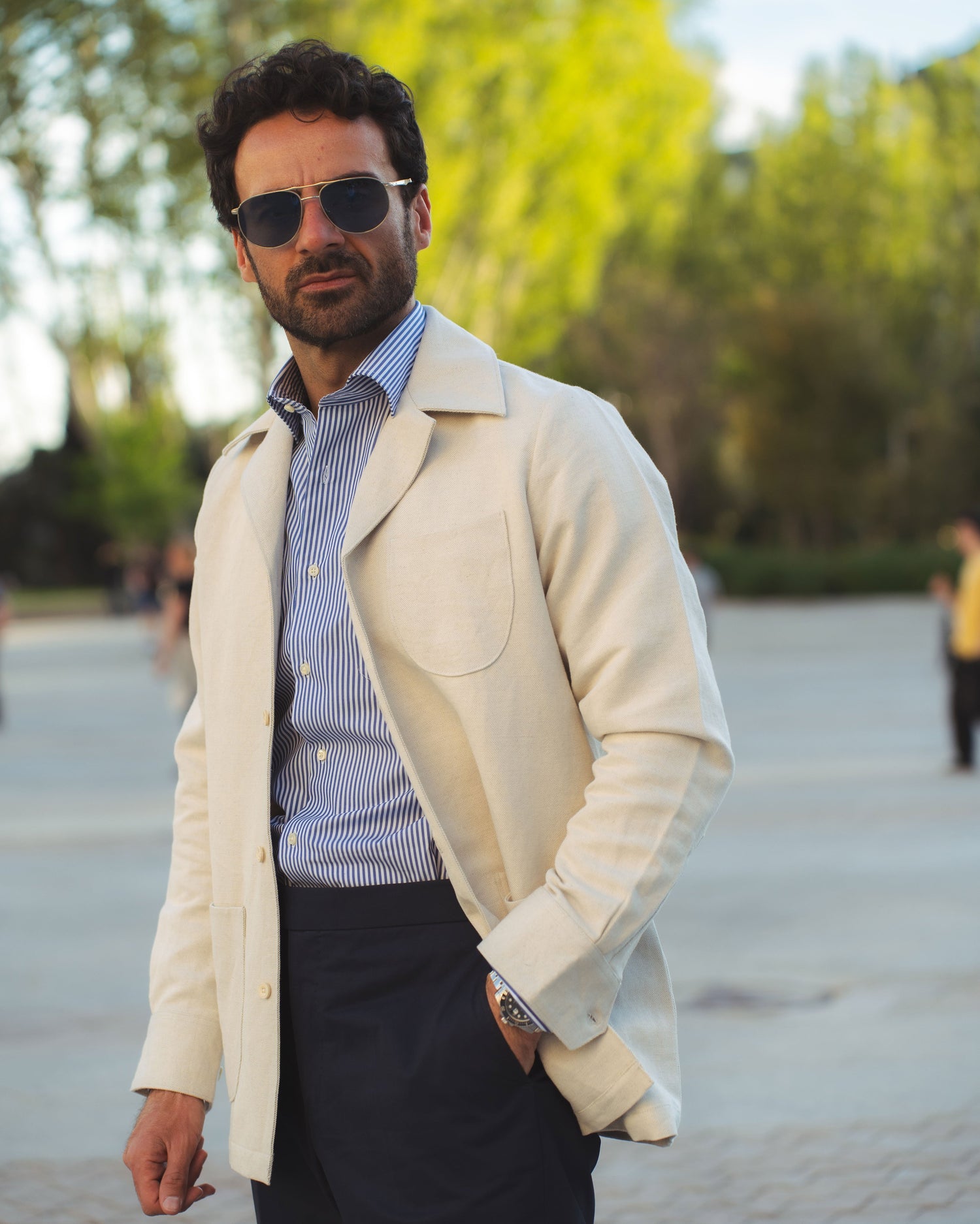 Model outside wearing the linen shirt jacket for men by Luxire in cream wearing striped shirt 3
